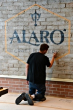 Alaro logo being painted onto an interior wall. Courtesy: Alaro Craft Brewery
